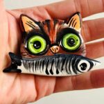 iman de gato castanho com sardinha