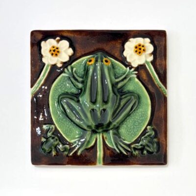 azulejo alto relevo de sapo verde com fundo castanho