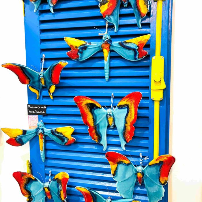 borboletas em ceramica penduradas numa parede azul