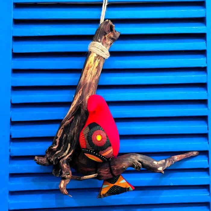 passarinho de tecido vermelho, pousado num galho de madeira