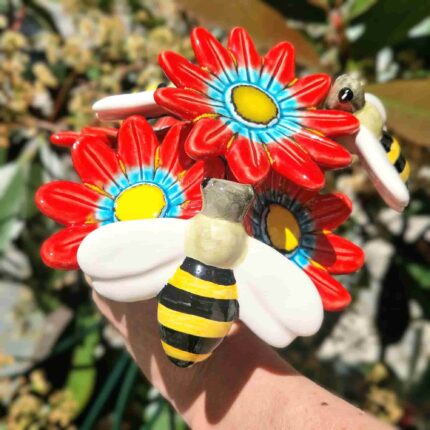 arranjo de flores vermelhas com abelhas em ceramica