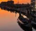 fotografia das ria de Aveiro ao por do sol com os moliceiros e os edifícios de arte nova