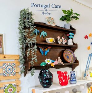 movel de madeira na parede da loja portugal care aveiro, com varias peças de artesanato português