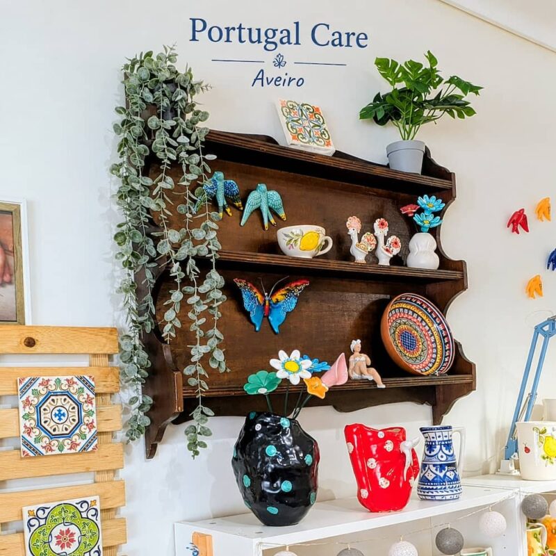 movel de madeira na parede da loja portugal care aveiro, com varias peças de artesanato português