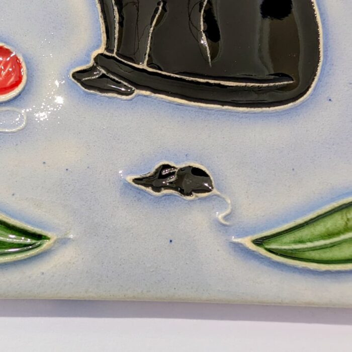 azulejo em relevo de gato sentado num fundo azul um ratinho