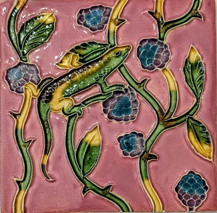 azulejo português em relevo de lagarto com plantas, num fundo cor de rosa