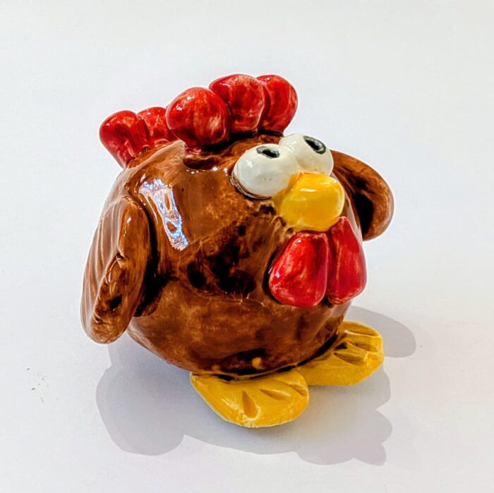 boneco de galinha em ceramica moldado á mão, nas cores castanha e vermelho