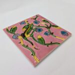 imagem perfil de azulejo português em relevo de lagarto com plantas, num fundo cor de rosa