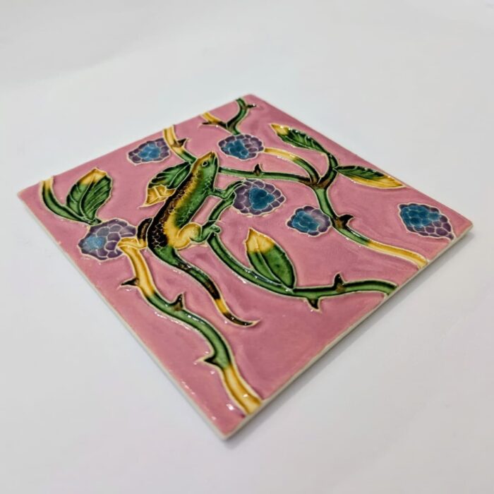 imagem perfil de azulejo português em relevo de lagarto com plantas, num fundo cor de rosa