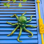 polvo em ceramica artesanal verde pendurado numa parede azul